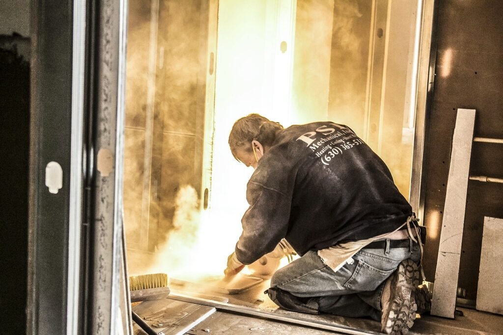 A man performing a property cleanout on a door with smoke coming out of it.