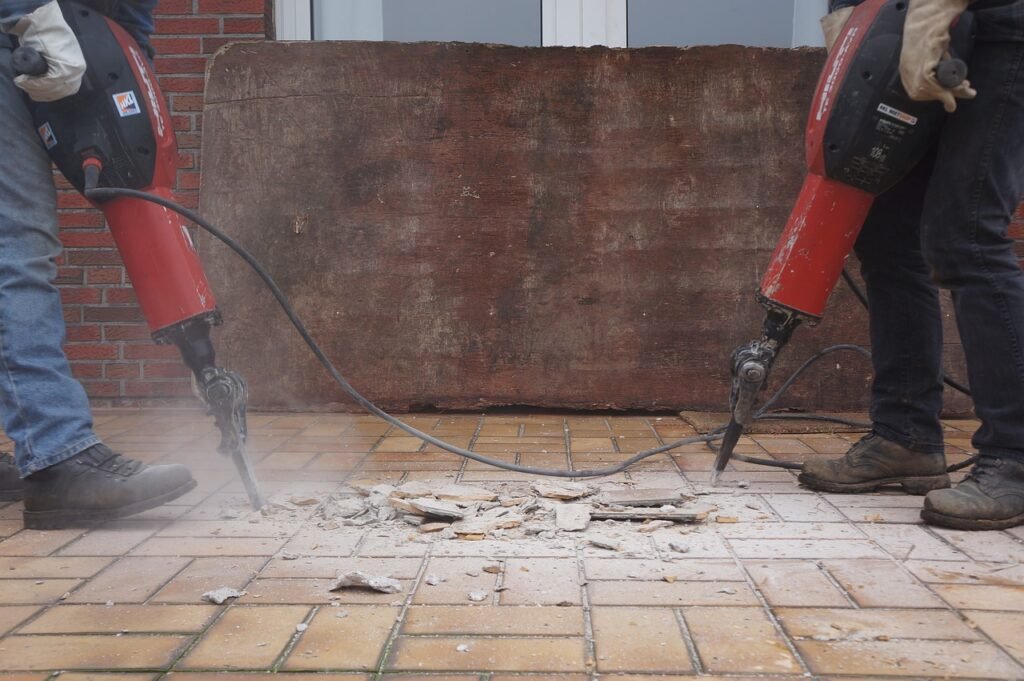 Two men performing brick floor installation.