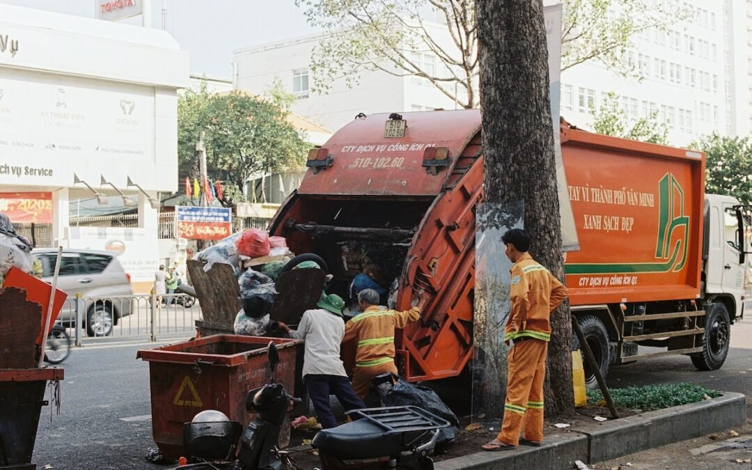 A garbage truck is parked on a street for junk removal.